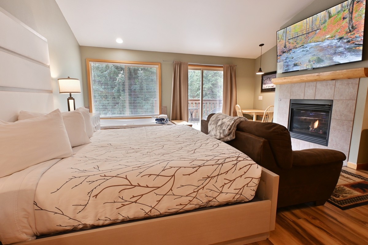 Stonebrook Riverview Suite with a king bed, fireplace, and private balcony